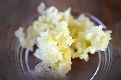 A small glass bowl holding minced garlic.
