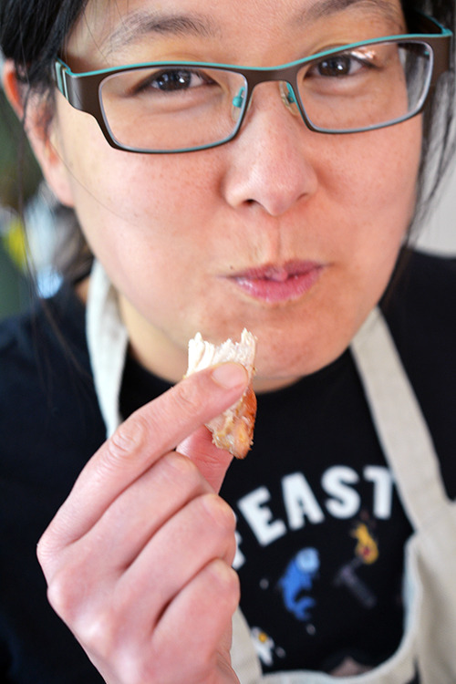 Michelle Tam eating a piece of Cracklin' Chicken 