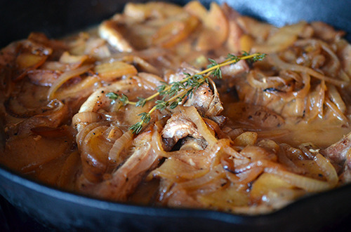 A pan of cooked Bacon Apple Smothered Pork Chops.