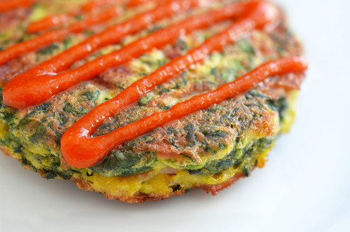 A Paleo Egg Foo Young patty with Whole30® Sriracha drizzled on it.