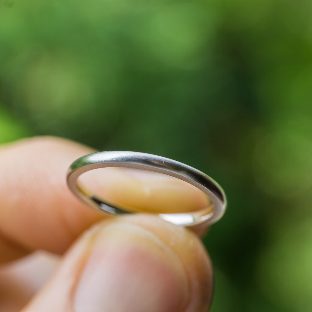 屋久島の緑の中　プラチナの結婚指輪を持つ
