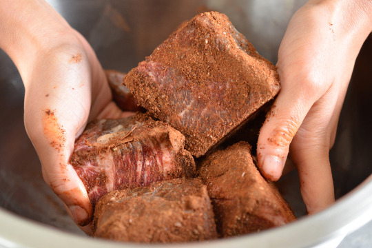 Someone tossing the beef cubes with the spice rub for the instant pot mocha-rubbed pot roast.