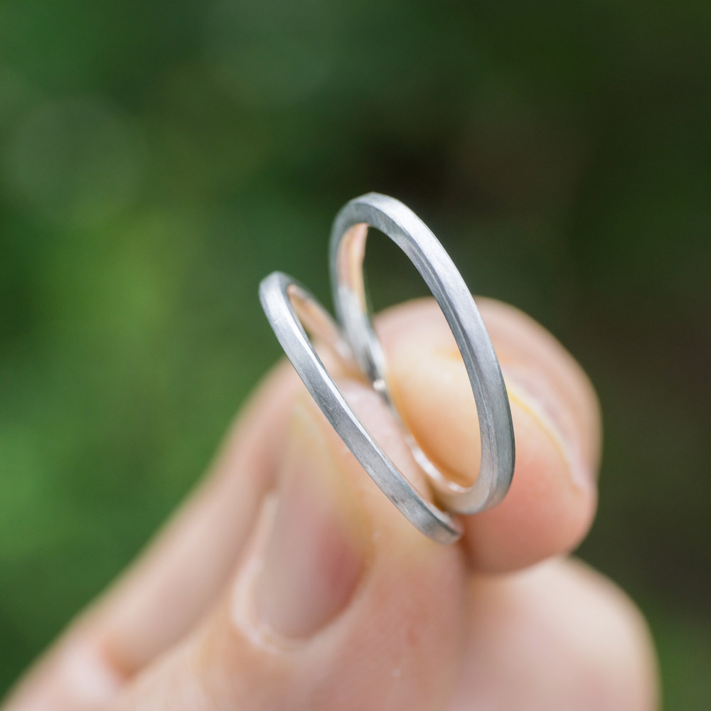 結婚指輪のサンプルリング　手に持って　屋久島の緑バック