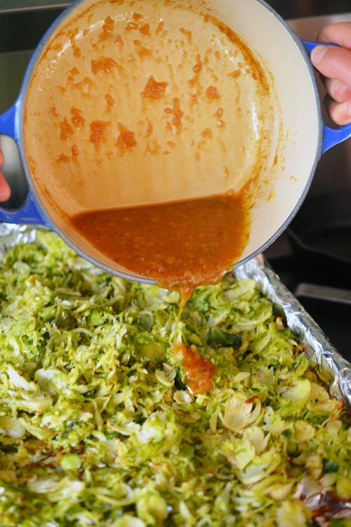 Pouring the Asian Citrus Dressing over the Warm Brussels Sprouts Slaw 