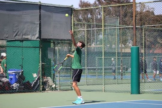Sophomore Kyle Sillman serves the ball during his doubles game at the boys Varsity CIF game on Monday after school. Mira Costa lost against University High School during their third CIF game. 