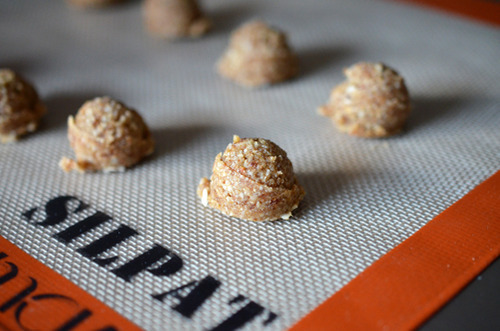 Nut-less balls sitting in two rows on a silicone baking sheet.