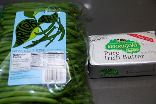 A pack of green beans sits next to a package of Irish butter.