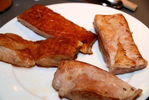Seared and sous vide cooked pork bellies sitting on a plate.
