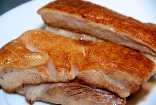 A plate of seared and sous vide pork belly sitting on a plate.
