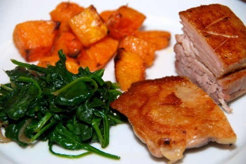 A dinner plate consisting of paleo and Whole30 cooked sous vide pork belly, chicken thighs, spinach, and butternut squash.