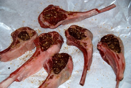 Six lamb chops sitting in butcher paper seasoned with Dukka, salt, and pepper.