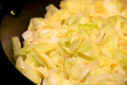 A close up of the stovetop braised cabbage in a cast iron pan.