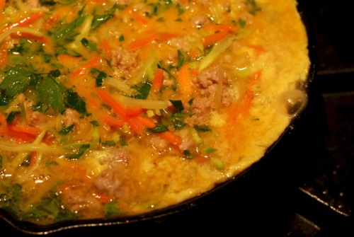 The curried ground pork and broccoli slaw frittata cooking in a cast iron skillet.