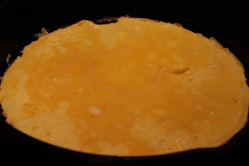 A thin egg omelette in a cast iron skillet.