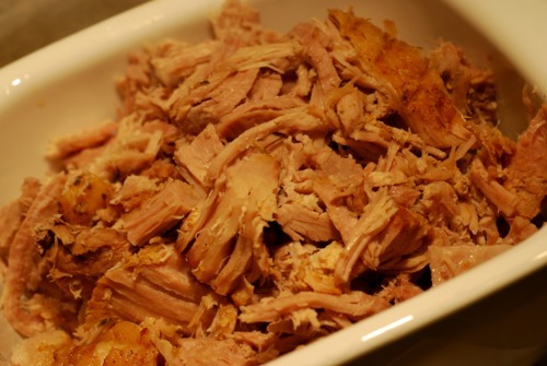 Shredded slow braised pork leg in a serving container.