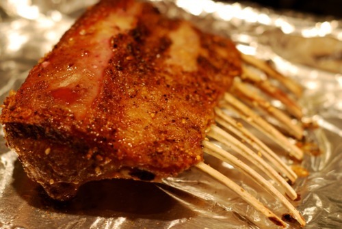 A cooked rack of lamb on a foil-lined baking sheet.