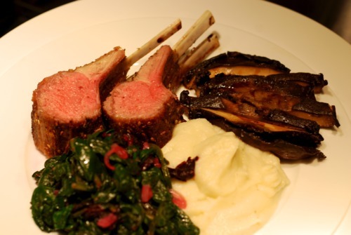 A plated Whole30 roasted rack of lamb on a plate with mashed cauliflower potatoes.