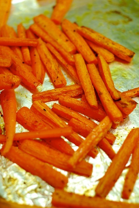 Carrot "fries" on an aluminum foil lined baking sheet.