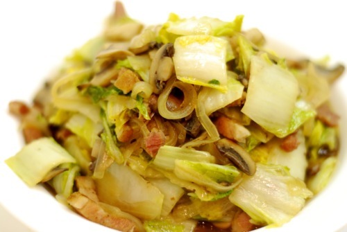 Stir fried Napa cabbage with mushrooms and bacon, a paleo and Whole30 recipe, are piled high in a bowl.