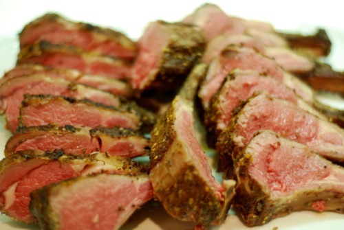 A seasoned and Frenched rack of lamb sliced up.