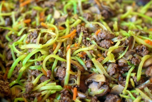 A close up of the meat mixture containing ground beef, broccoli slaw, mushrooms, and onions for the muffin frittatas.