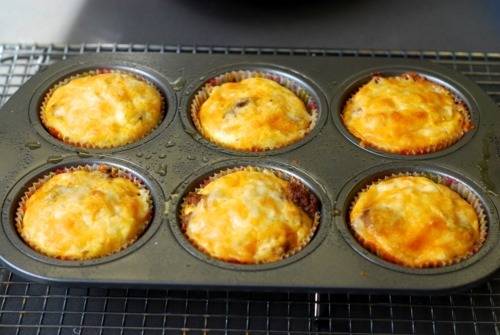 Six cooked mini frittata muffins with cheese and bacon.
