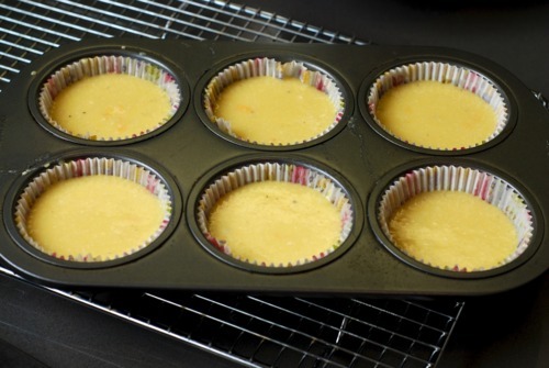 The batter of cheesy egg muffins divided up into a 6 muffin tin.