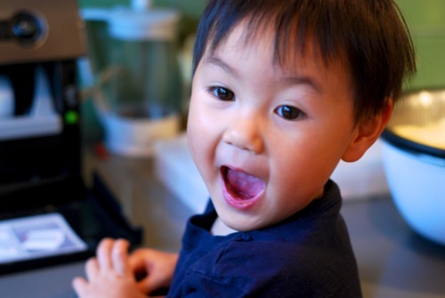 A child with an excited look on his face. His mouth is open and he is looking away from the camera.