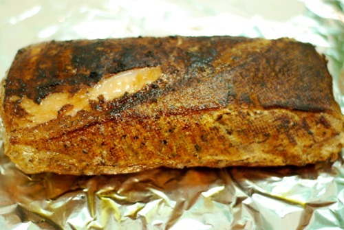A close up of a pork loin after it has been charred by a kitchen torch.