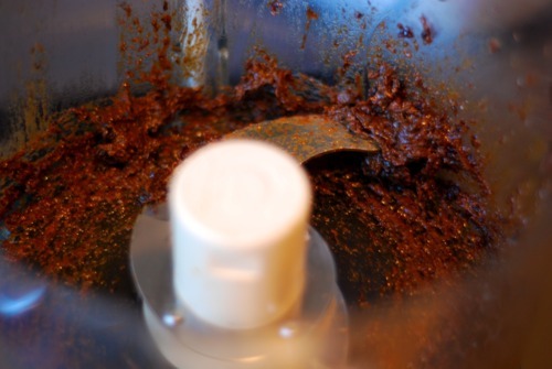 An overhead view inside a food processor with pureed prunes inside.