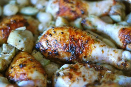 The cooked drumsticks are tucked into the pan with the frozen onions, artichokes, and garlic.