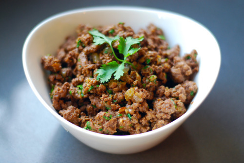 Cooked ground beef in a bowl topped with cilantro.