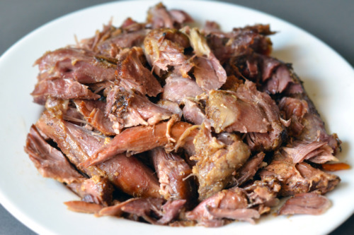 Shredded slow cooker curried goat meat on a plate.