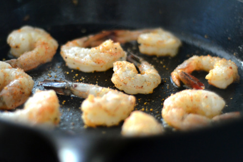 Shrimp sautéing in a cast iron pan for Sautéed Shrimp with Onions and Cherry Tomatoes.