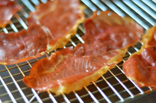 Baked prosciutto cooling down on a wire rack.