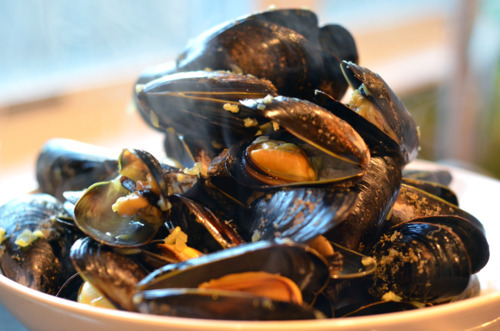 A bowl of mussels with the butter mixture poured over.