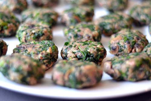 A plate of mini burgers that are made with beef, spinach, and mushrooms.