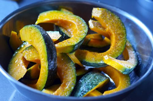 The wedges of kabocha squash are tossed with melted fat and seasoning 