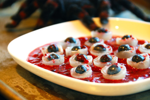 Bloody eyeballs, or longan stuffed blueberries, in a bowl with a berry smoothie as blood.