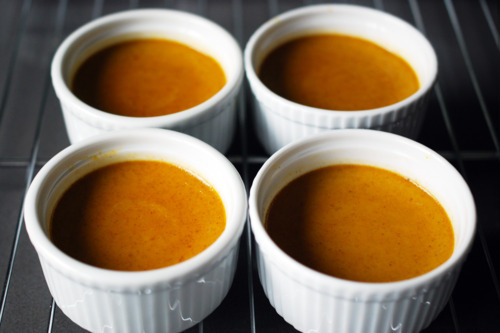 Four paleo pumpkin custard cups are on a cooling rack.
