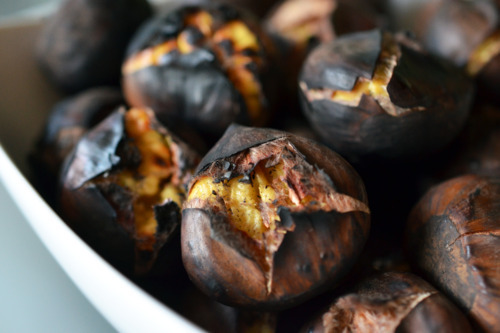Charred and roasted chestnuts in a bowl.
