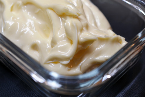 Closeup of thick mayonnaise stored in a glass container.