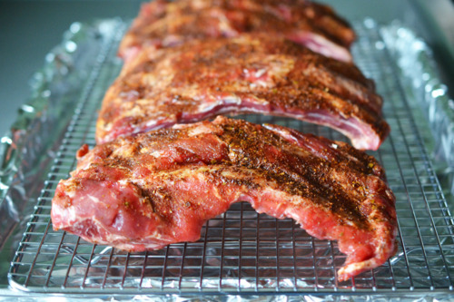 Raw and seasoned ribs placed on a wire rack to be pressure cooked.