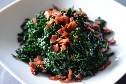 A bowl of stir-fried kale with bacon.