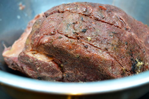 The beef chuck roast taken out of the vacuum sealed bag and placed in a metal bowl.