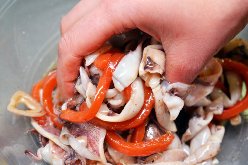 Mixing the ingredients for grilled calamari and roasted red peppers.