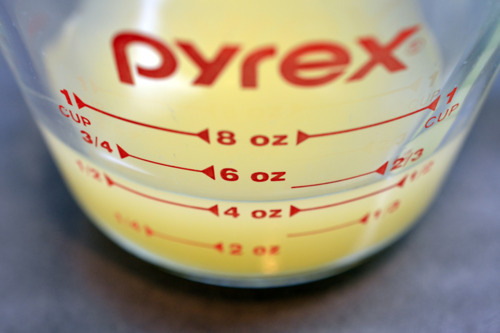 Measured chicken broth in a glass container.