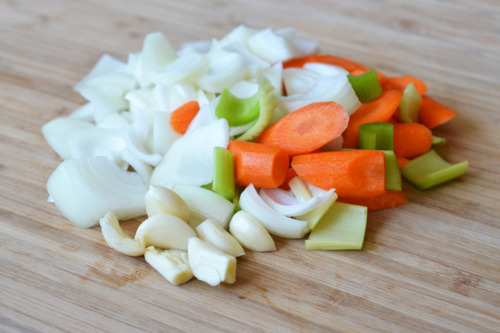Chopped up veggies on a cutting board for Porcini and Tomato Beef Short Ribs.