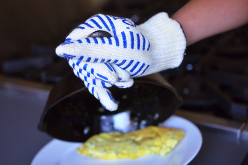 Transferring the cooked omelet onto a plate.