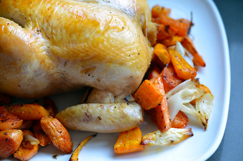 Closeup of Julia Child's Classic Roast Chicken on a platter with roasted vegetables.